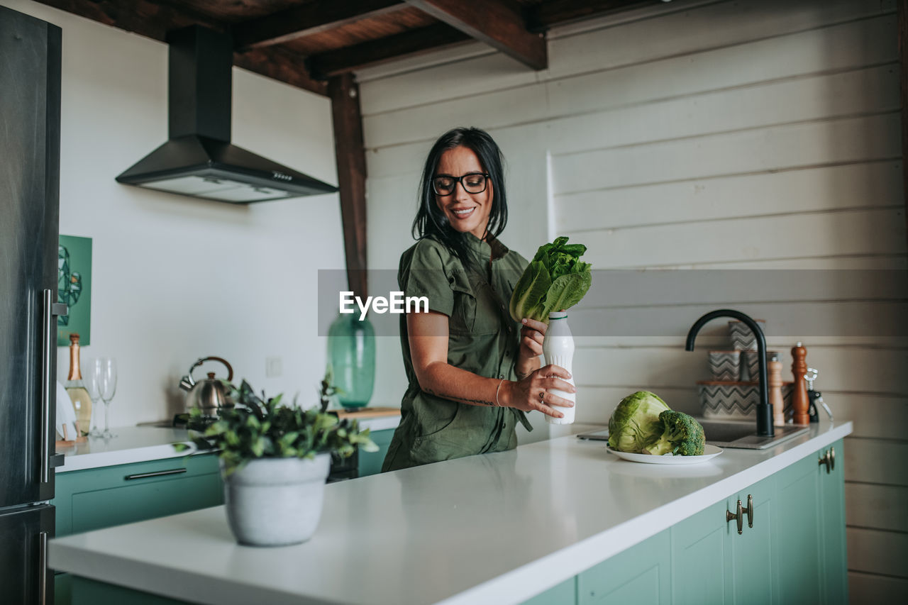 Portrait of smiling woman standing at home