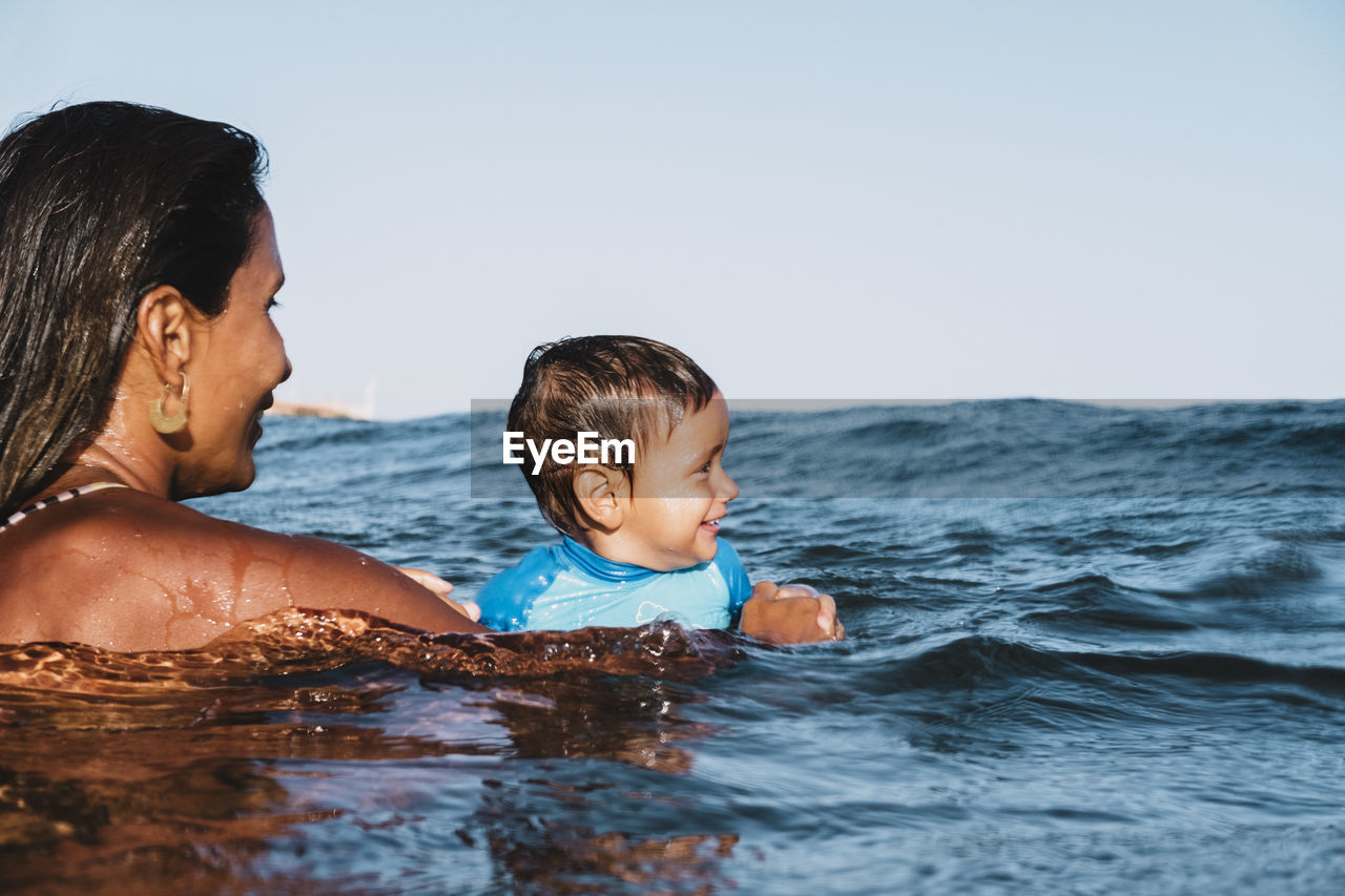 Portrait of mother and son playing at sea