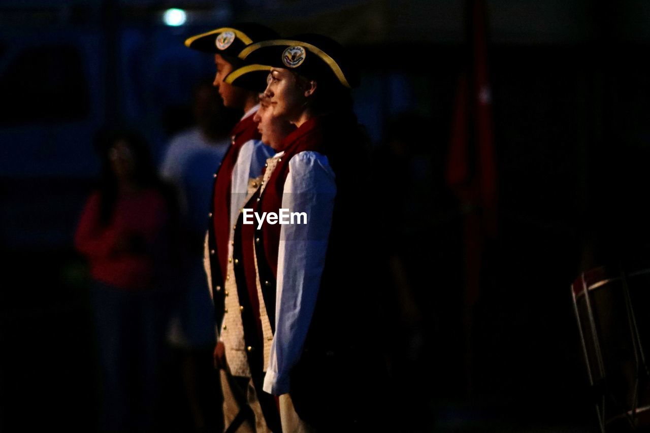 MIDSECTION OF MAN STANDING AT NIGHT