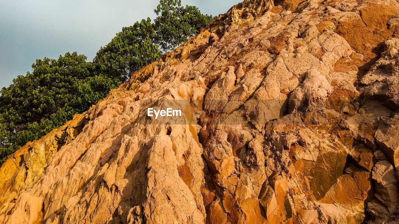 LOW ANGLE VIEW OF ROCK FORMATION ON MOUNTAIN AGAINST SKY