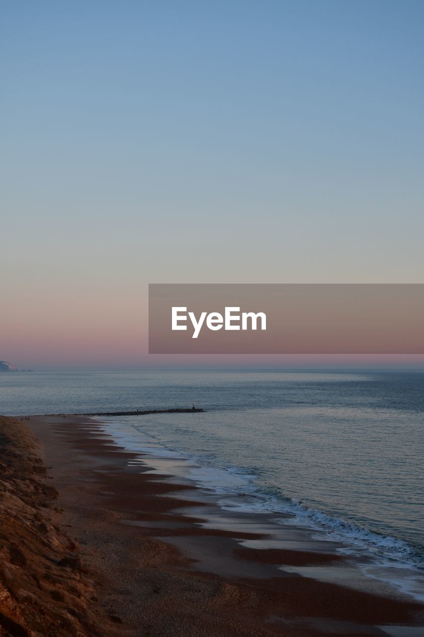 Scenic view of sea against clear sky during sunset in dorset 