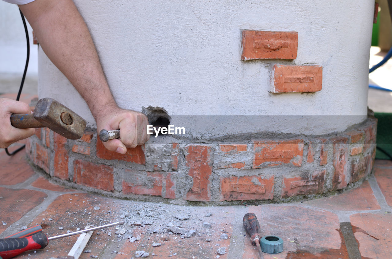Making a hole in a concrete by hands with hammer and chisel