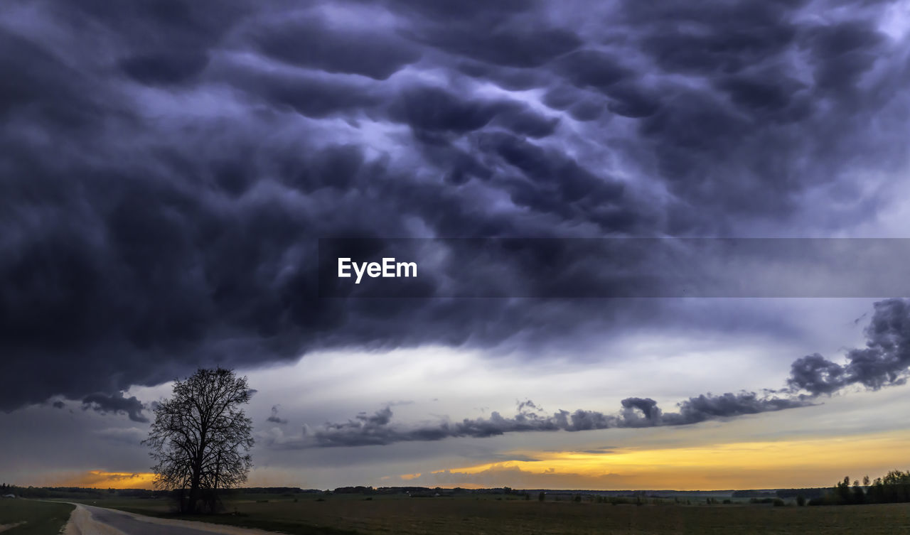 STORM CLOUDS OVER LANDSCAPE DURING SUNSET