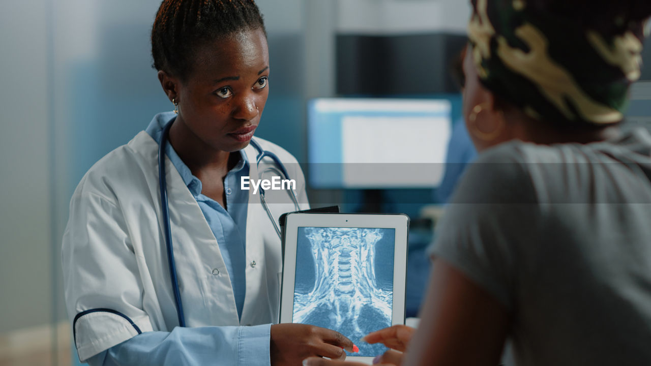 Doctor showing medical x-ray to patient