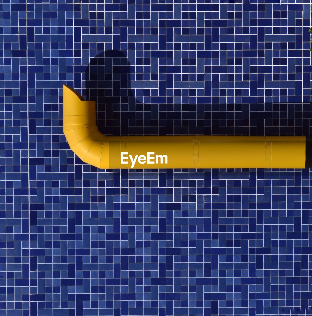 Yellow tube on blue wall