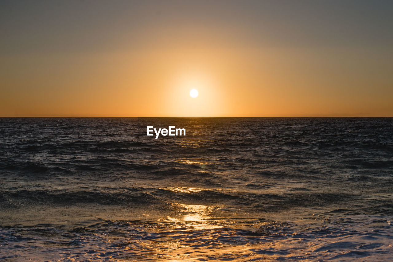 Scenic view of sea against clear sky during sunset