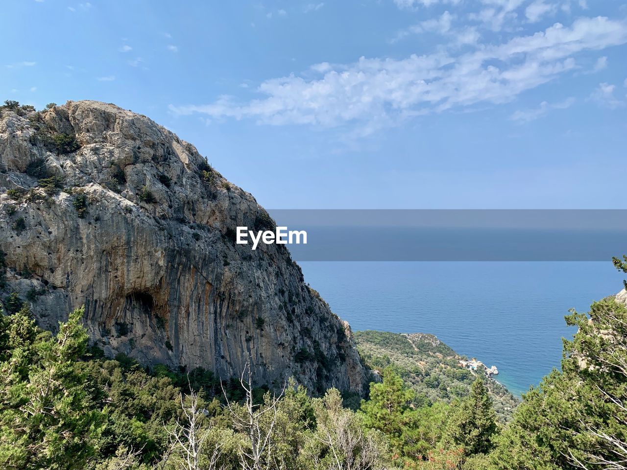 Scenic view of rocks by sea against sky