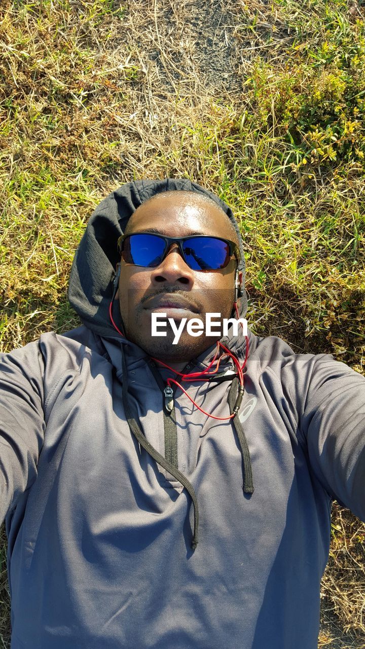 PORTRAIT OF YOUNG MAN WEARING SUNGLASSES