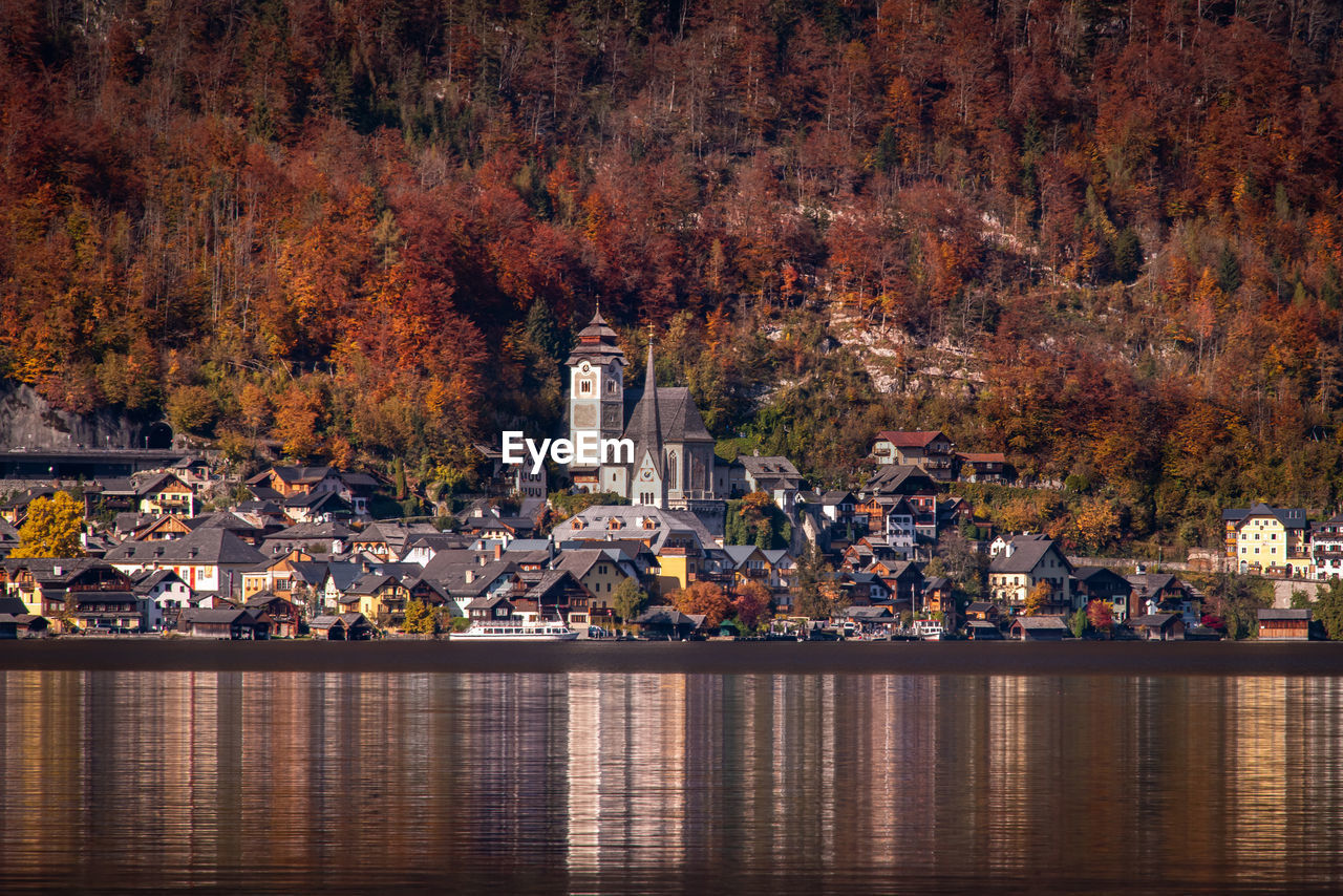 View of buildings by lake during autumn