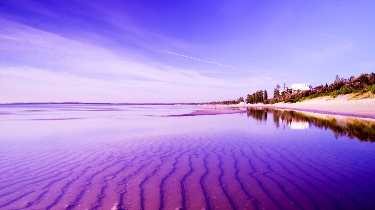 Scenic view of beach against blue sky