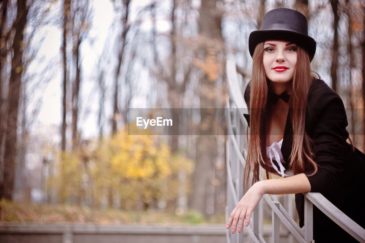 Portrait of beautiful woman standing in forest during autumn