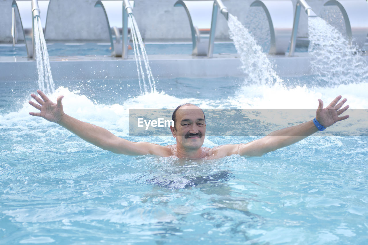 Man in thermal pool with hydromassage and  injectors with water jets