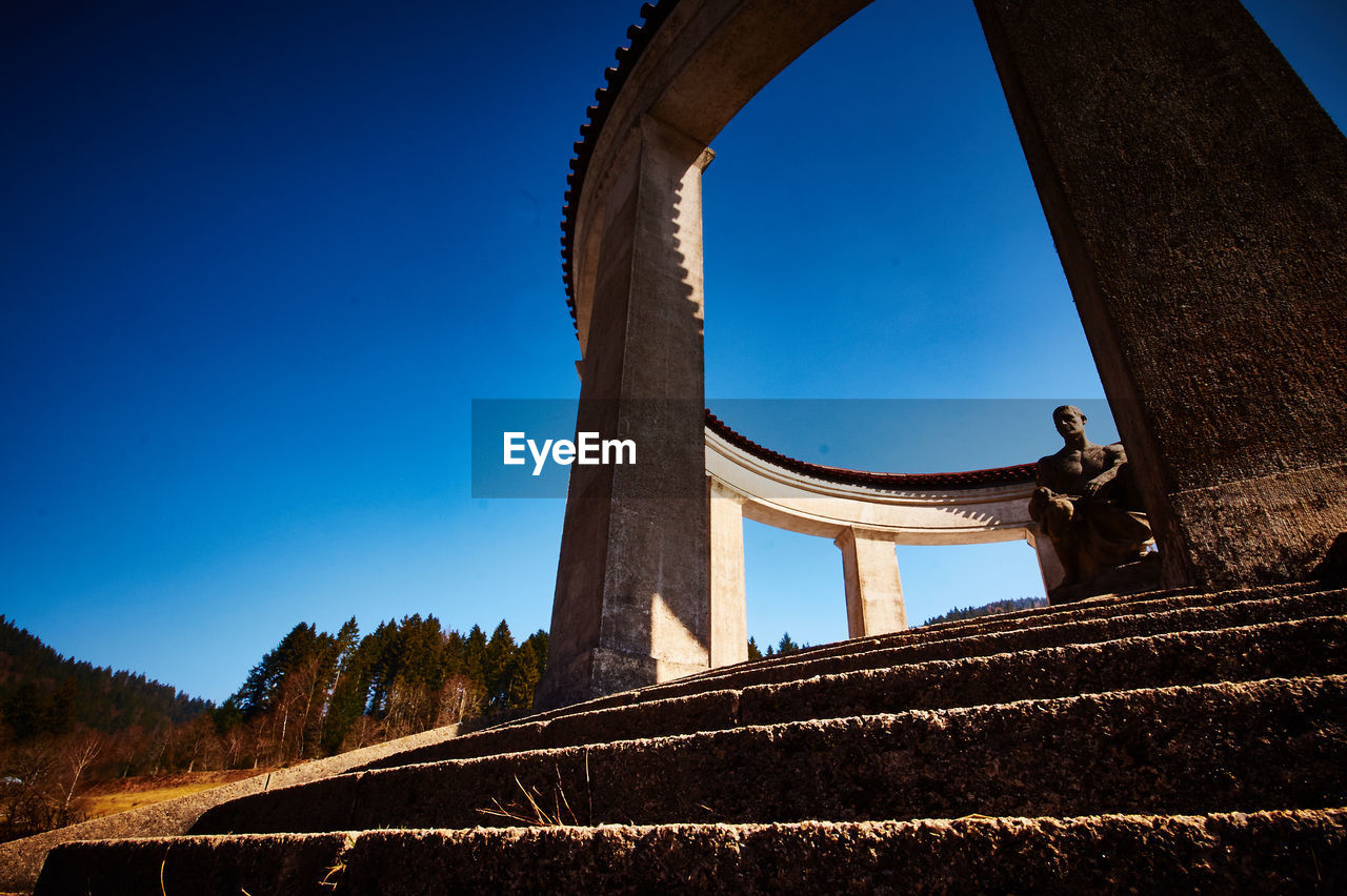 Low angle view of memorial against clear blue sky