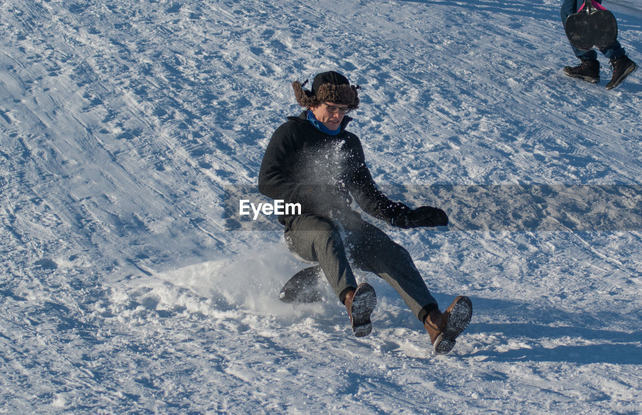 Low angle view of man sliding downhill on steep snow