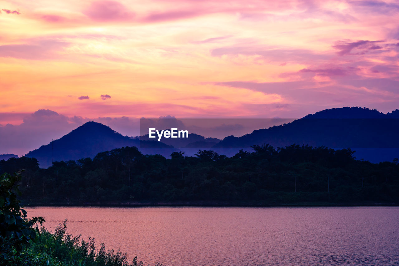 Silhouette mountain with attractive background, sunset with vivid purple sky and lake