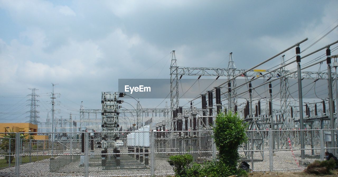 ELECTRICITY PYLON AND BUILDINGS AGAINST SKY