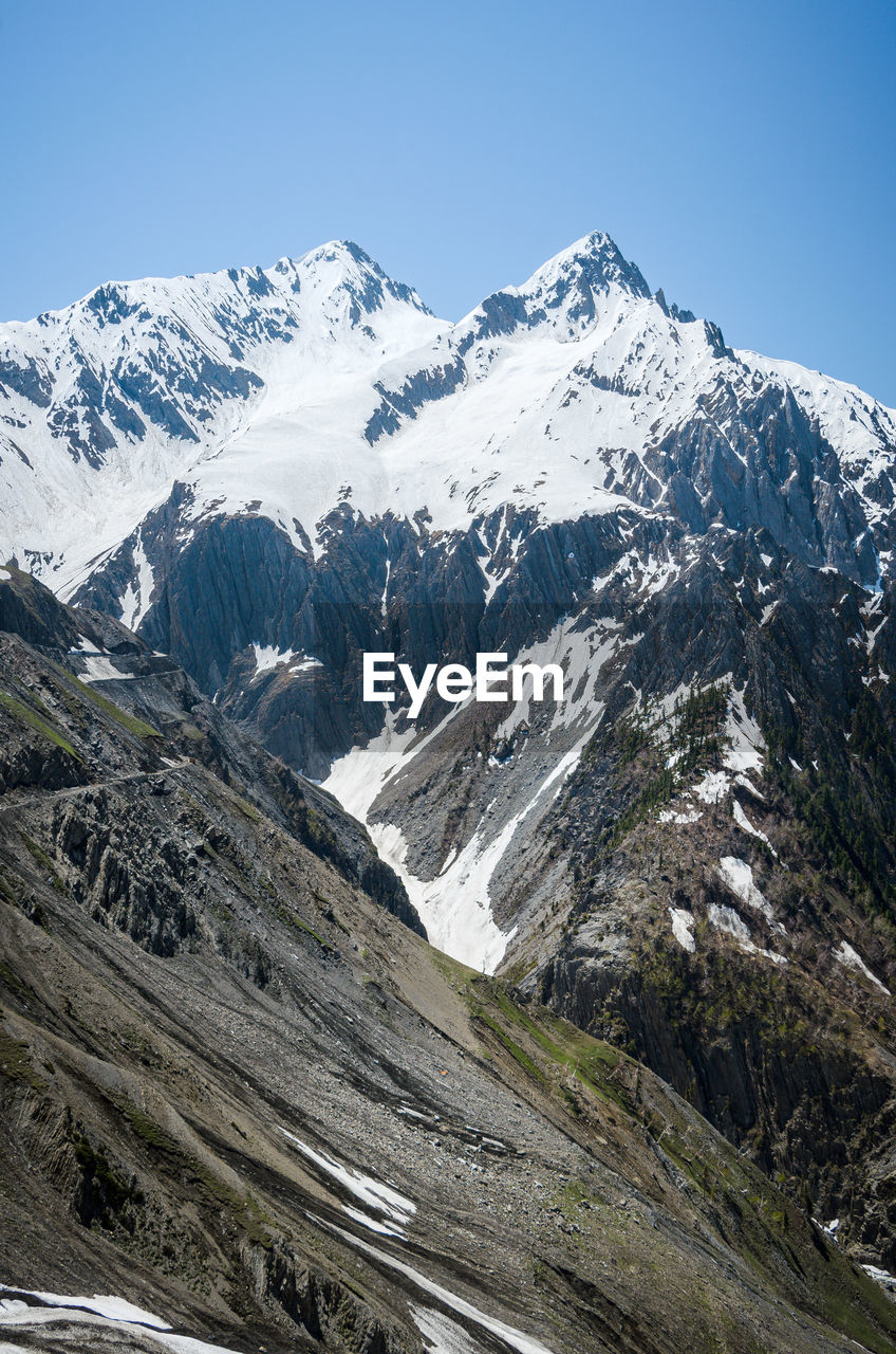 Scenic view of snowcapped mountains against clear sky