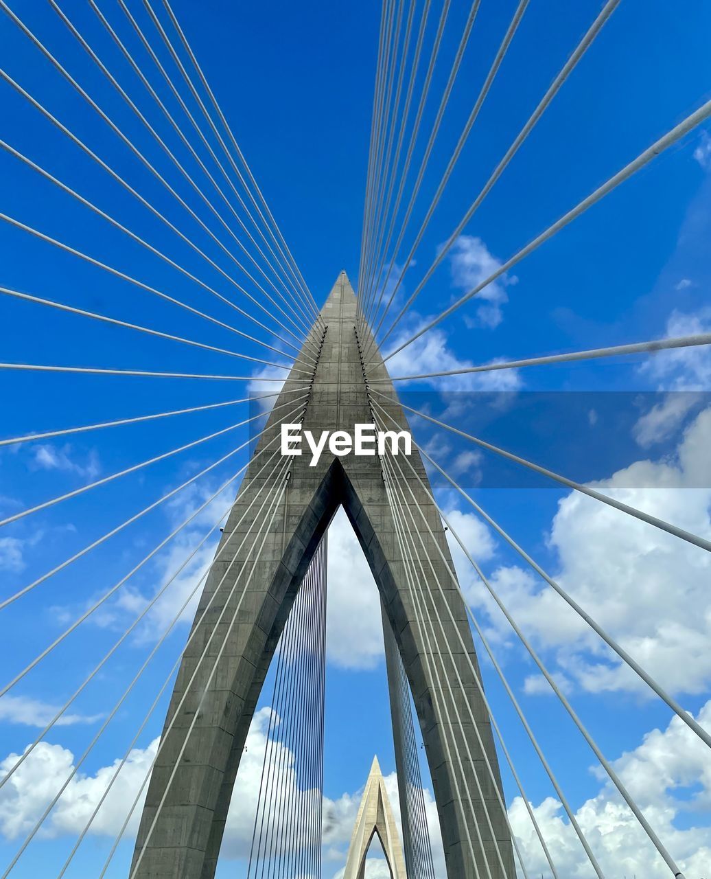 sky, architecture, built structure, cable-stayed bridge, bridge, transportation, suspension bridge, blue, cloud, city, engineering, nature, steel cable, travel destinations, landmark, low angle view, building exterior, cable, travel, day, skyscraper, outdoors, cityscape, tourism, line