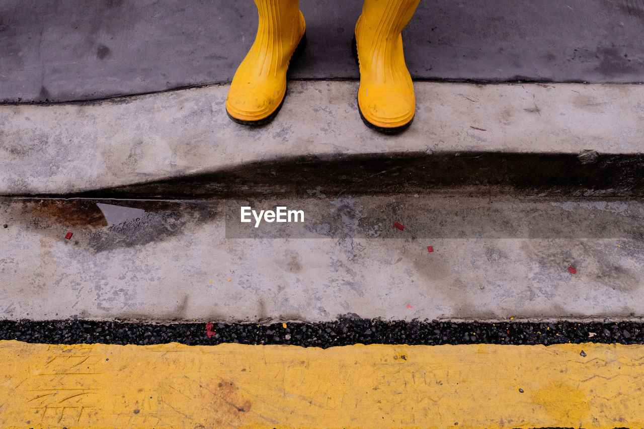 Low section of person standing on wet street