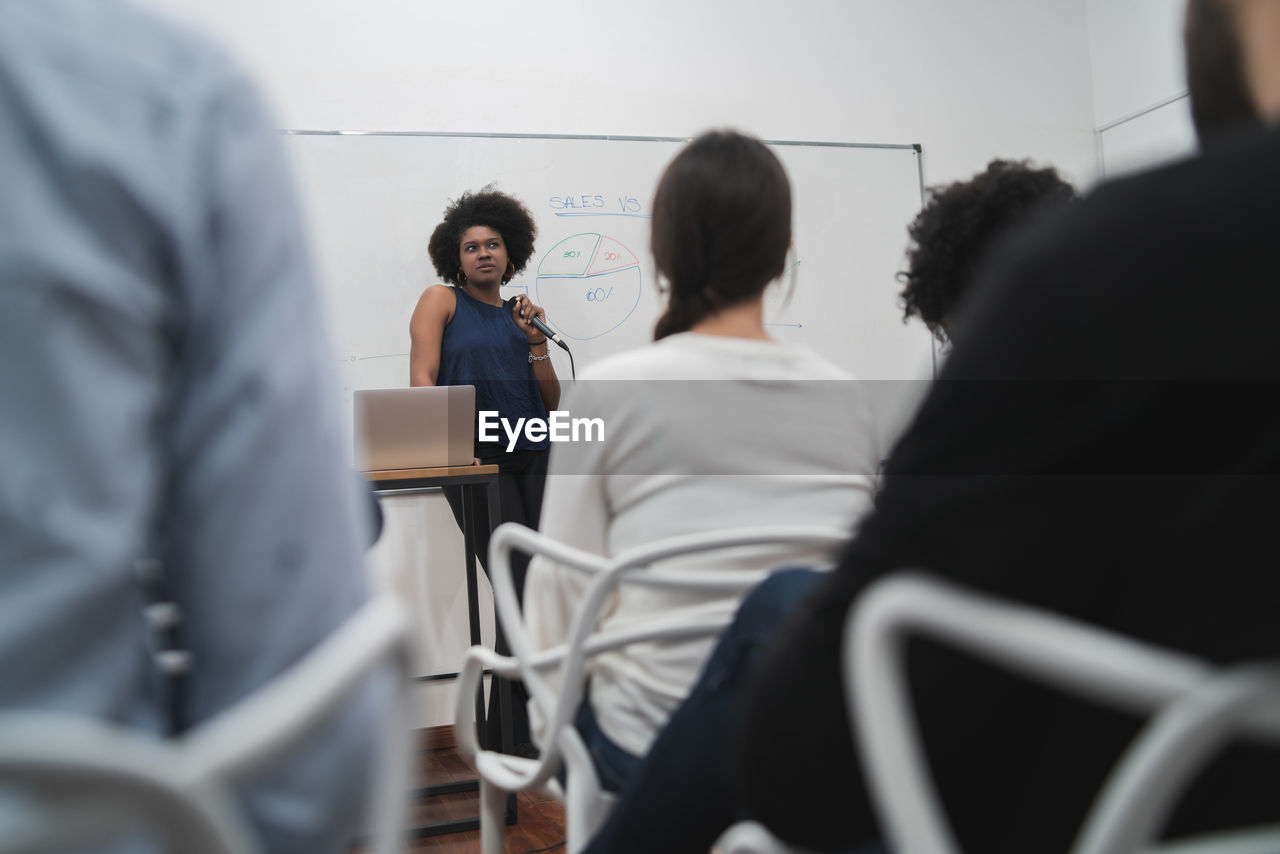 Young woman giving presentation in meeting