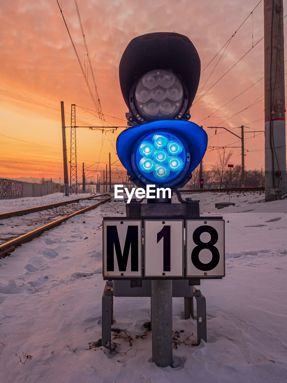 sky, sunset, sign, nature, transportation, road, snow, communication, road sign, winter, cloud, cold temperature, blue, no people, technology, landscape, environment, vehicle, screenshot, city, rail transportation, outdoors, architecture, travel, dusk, electricity, mode of transportation