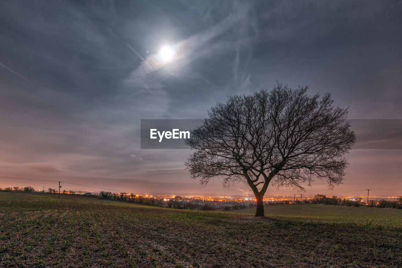 Scenic view of grassy field against cloudy sky