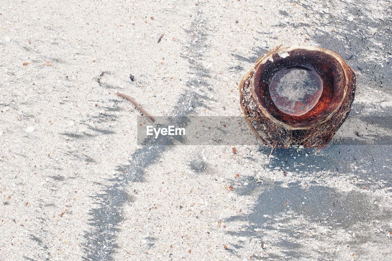 HIGH ANGLE VIEW OF RUSTY METAL ON ROAD BY STREET