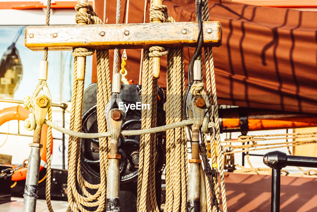 CLOSE-UP OF ROPES TIED ON ROPE AGAINST BOAT
