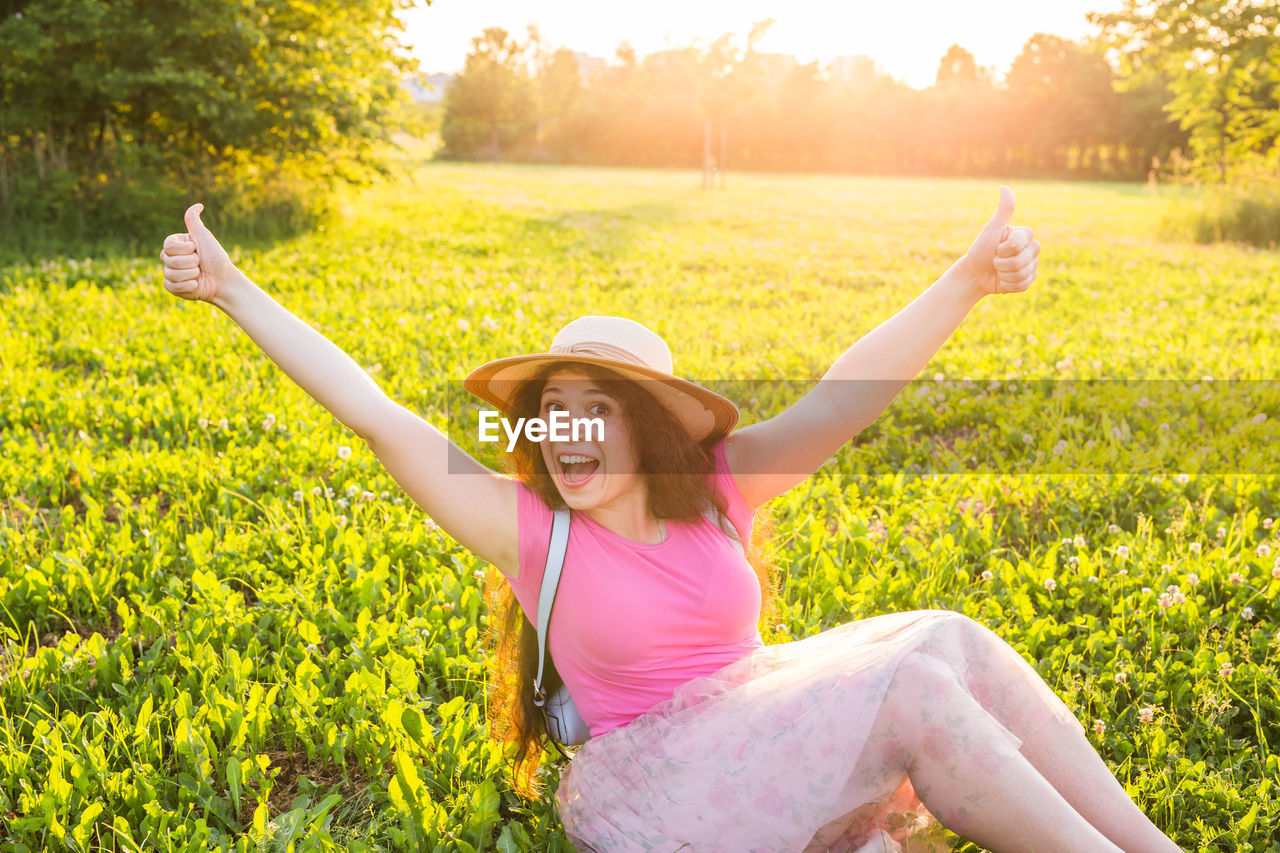 PORTRAIT OF HAPPY WOMAN ON FIELD