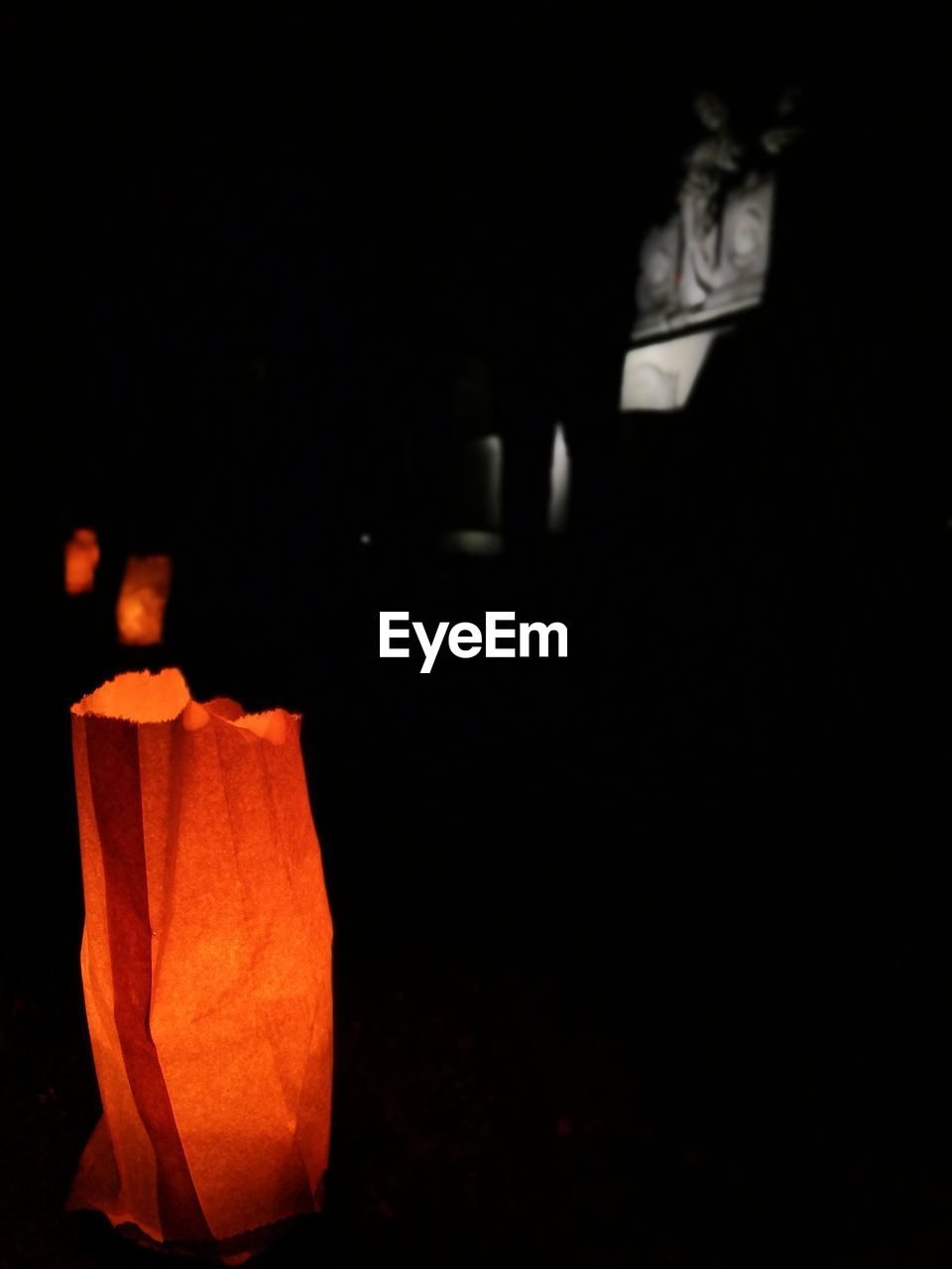 CLOSE-UP OF ILLUMINATED PUMPKIN IN DARK ROOM