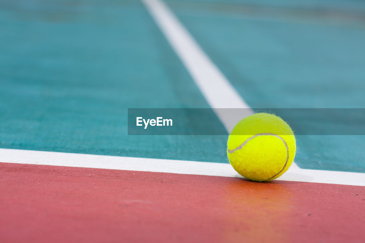 Close-up of yellow ball on tennis court