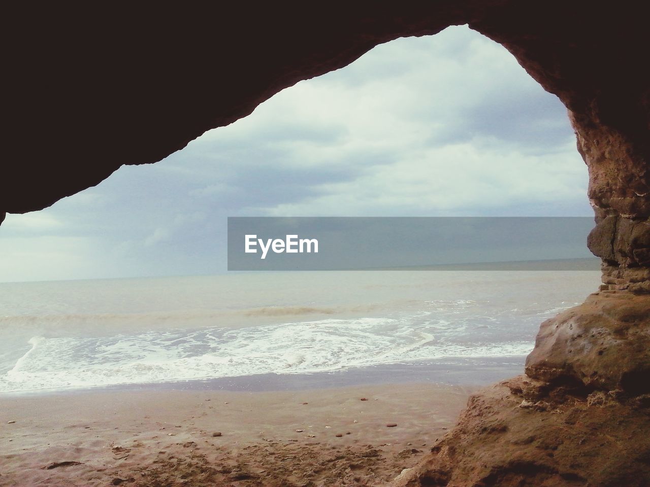 VIEW OF BEACH AGAINST CLOUDY SKY