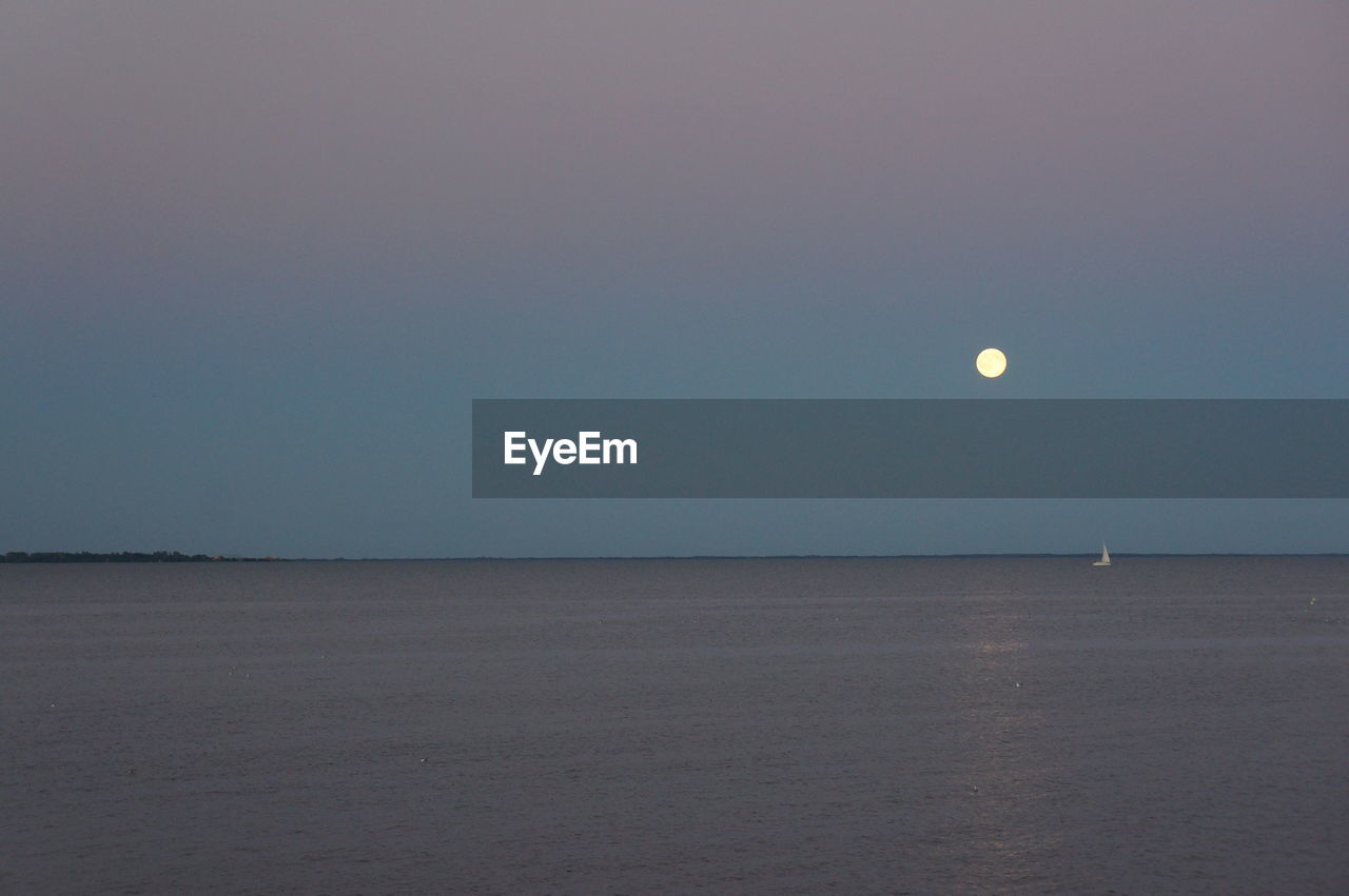 SCENIC VIEW OF SEA AGAINST MOON AT NIGHT