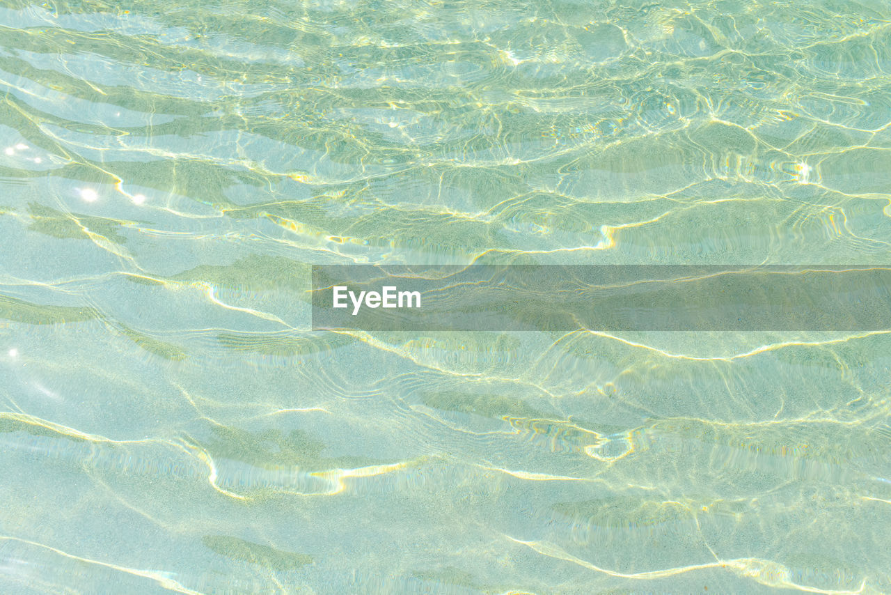 Swimming pool blue water with a wave and sunlight reflection effect