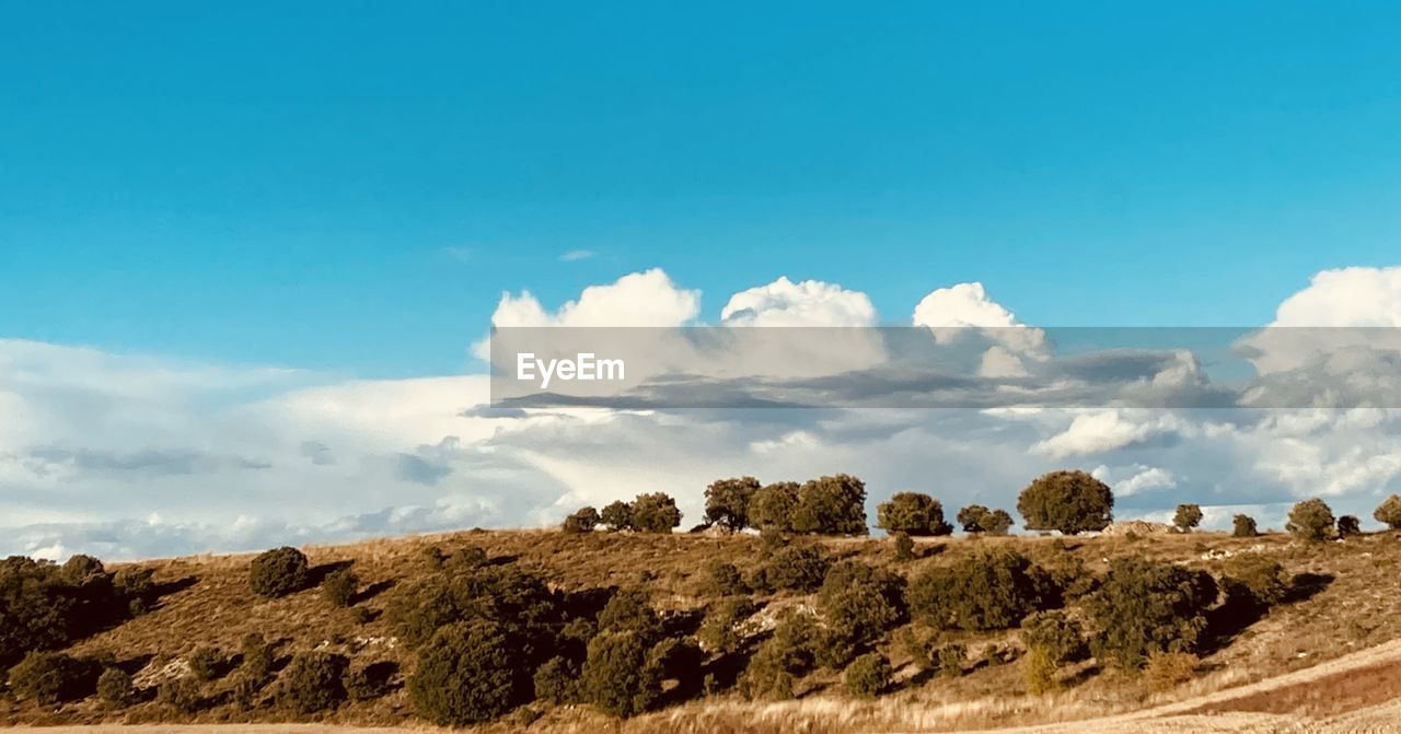 Panoramic view of landscape against blue sky