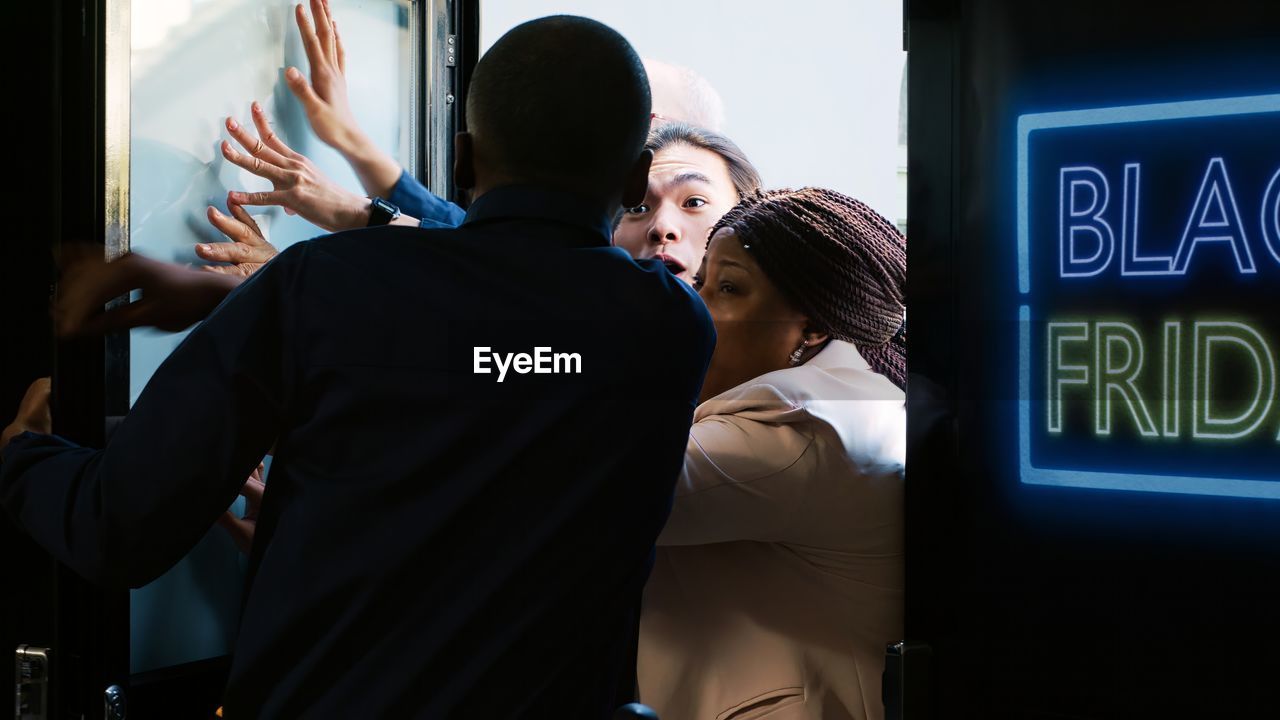 rear view of man looking through window at airport