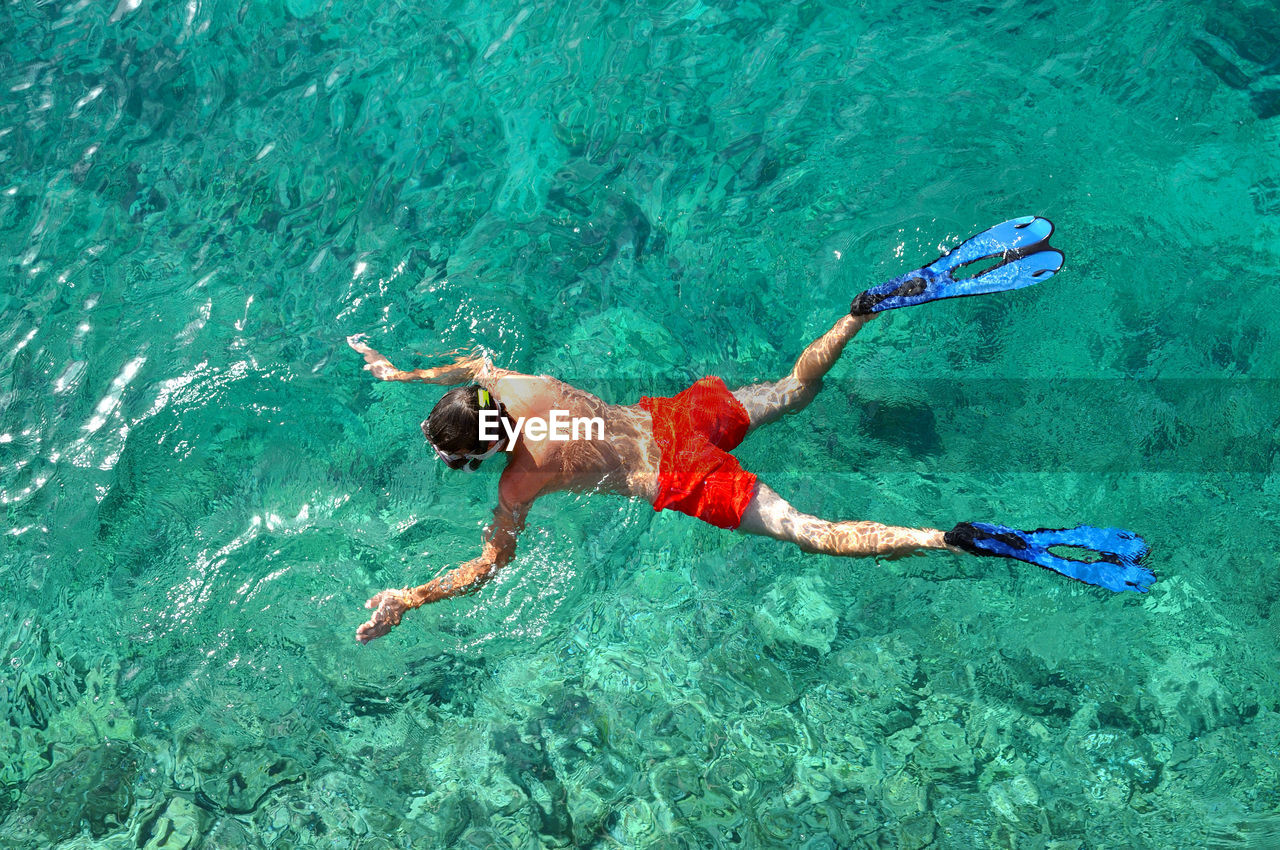 Aerial drone view of a guy snorkeling in a tropical sea