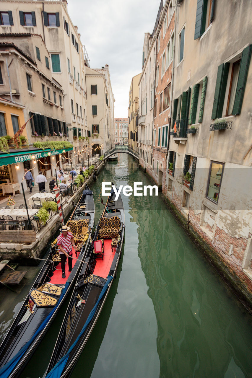 boats in canal amidst buildings in city