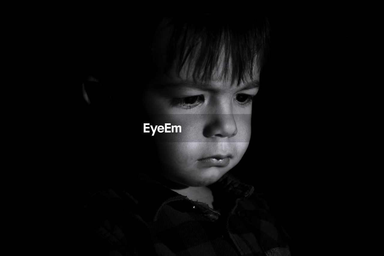  cute boy looking away against black background