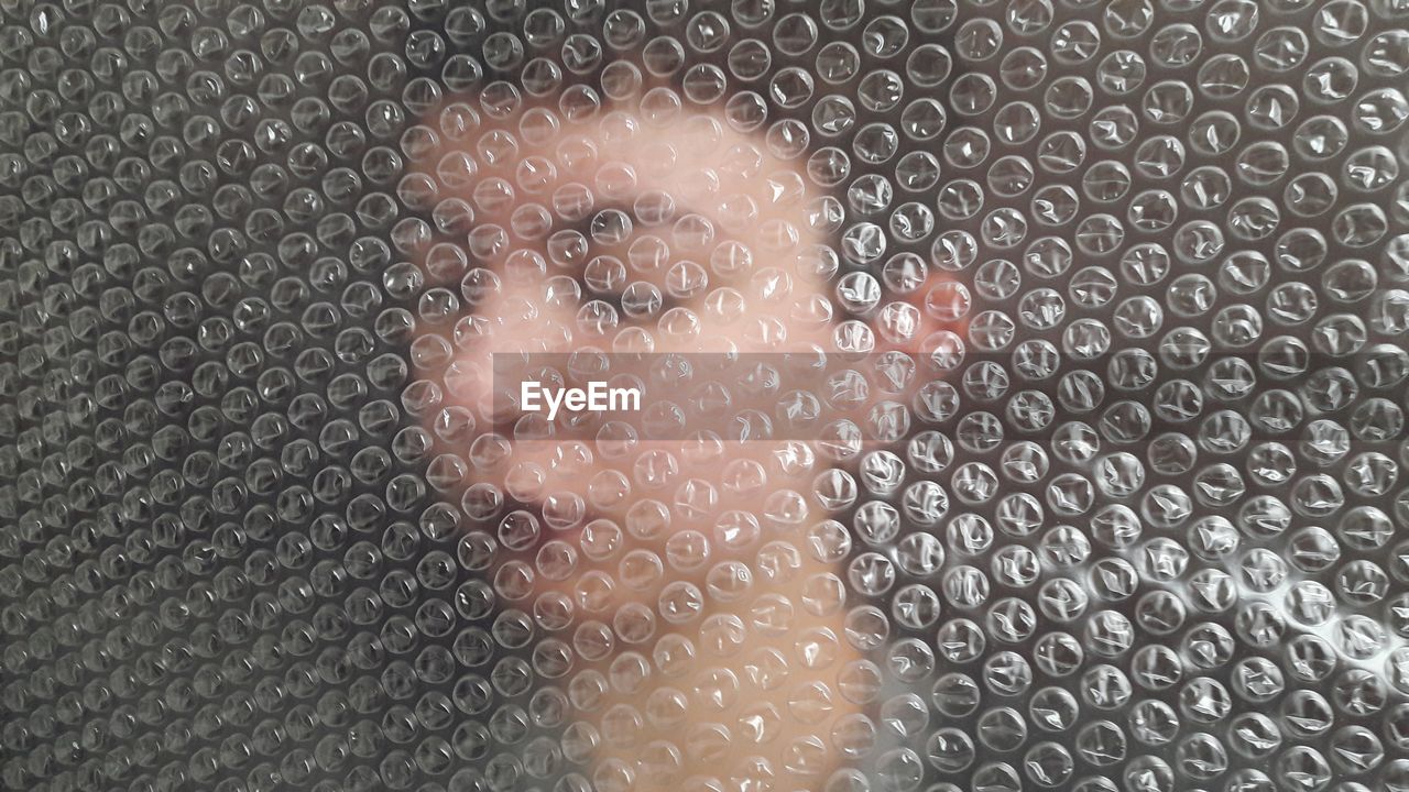 DIGITAL COMPOSITE IMAGE OF WOMAN LOOKING THROUGH METAL