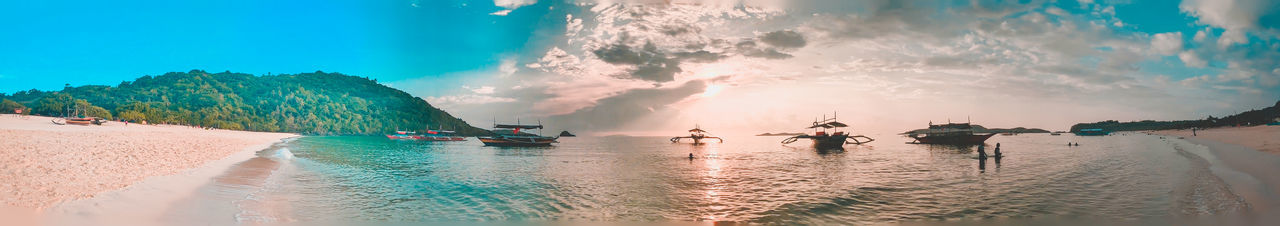 Panoramic shot of people on beach against sky