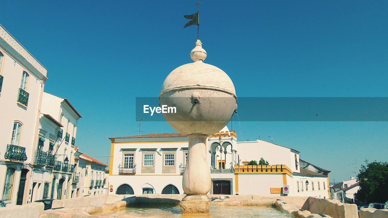 Fountain against residential buildings in city