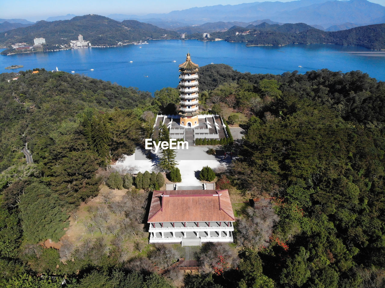 HIGH ANGLE VIEW OF BUILDING BY SEA AGAINST MOUNTAIN