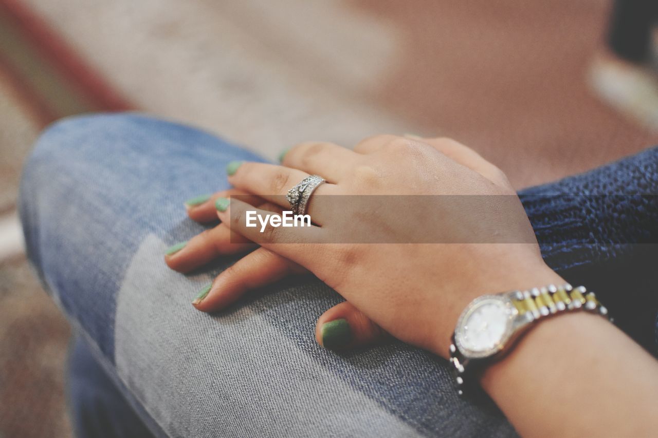 Close-up of woman wearing wristwatch and ring