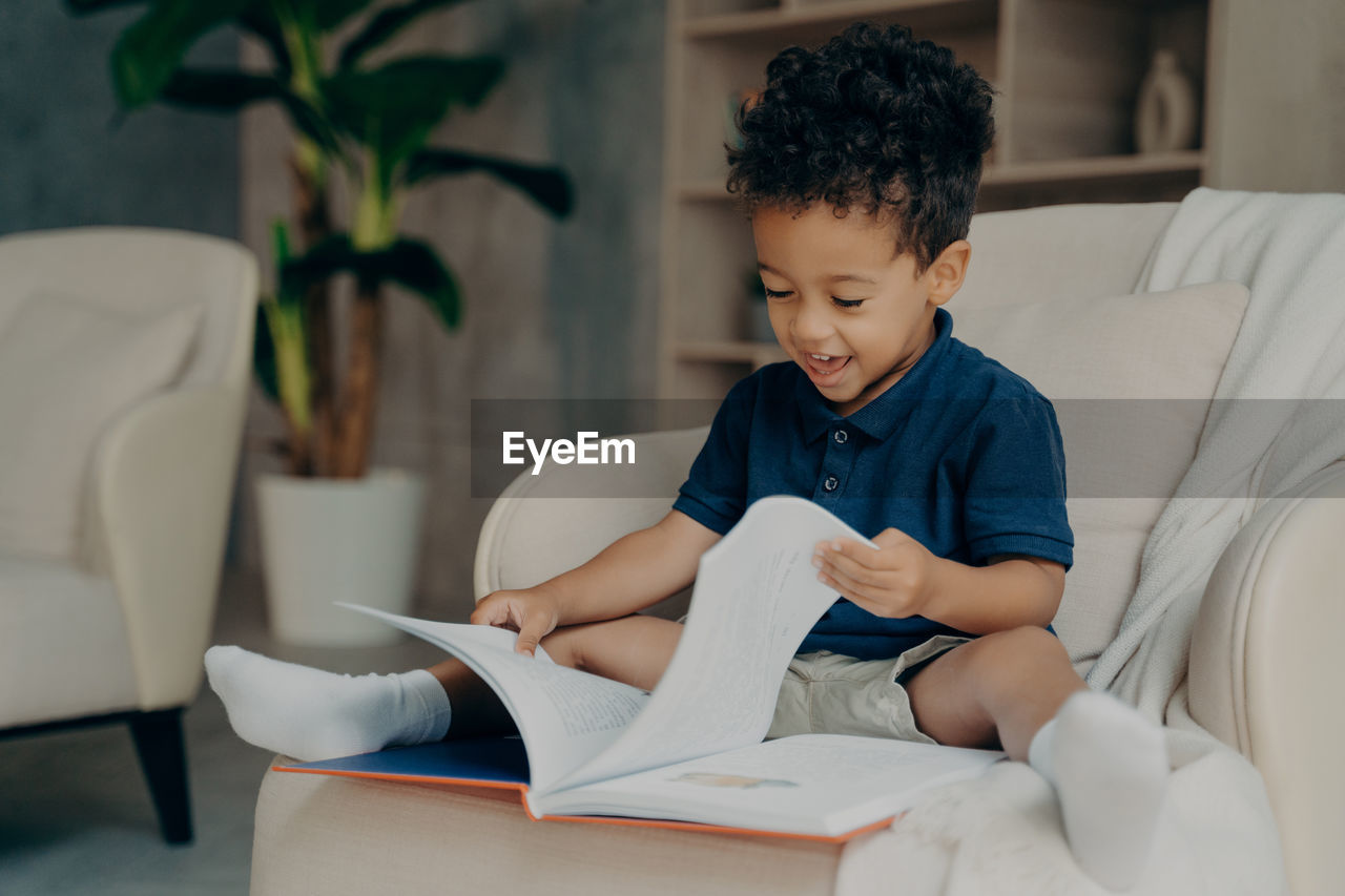 Boy with book sitting at home