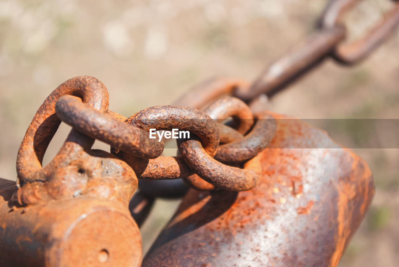 Old rusty chain on the field on ground background