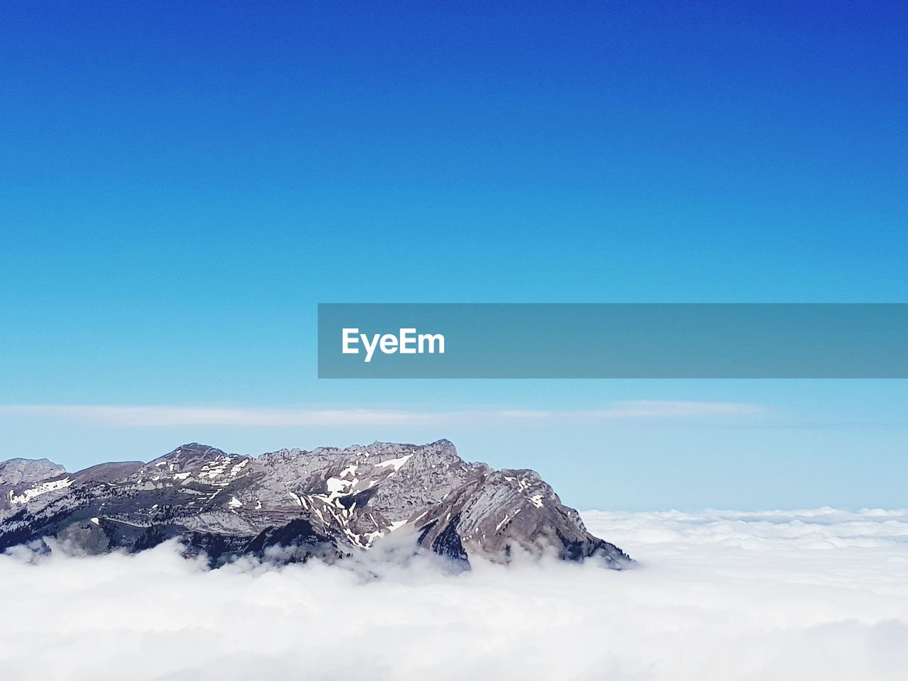 Scenic view of snowcapped mountains against clear blue sky