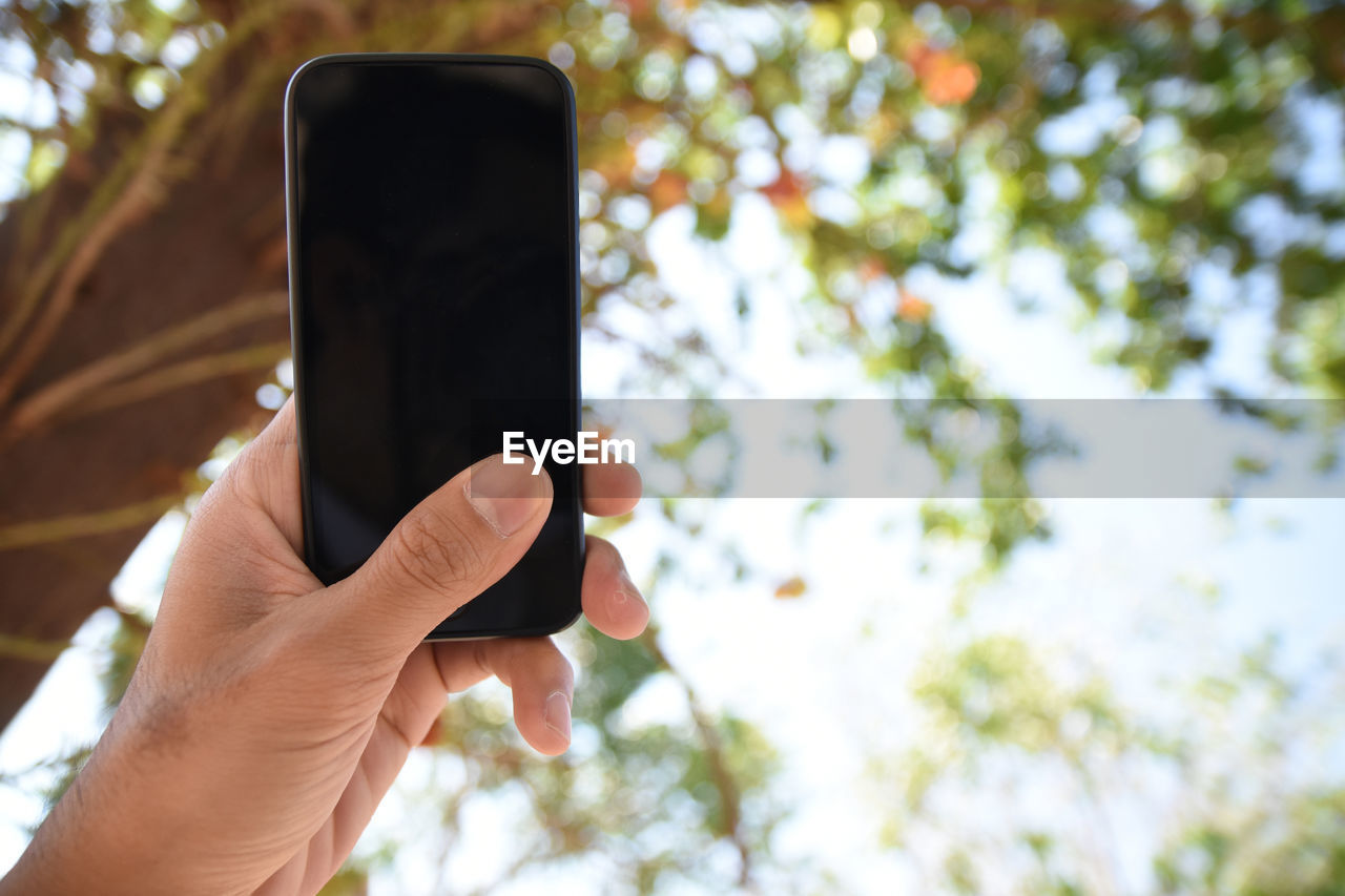 CLOSE-UP OF HAND HOLDING CAMERA