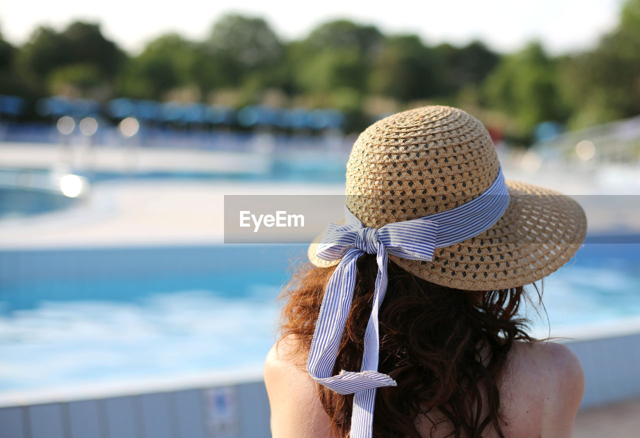 Beautiful woman with straw hat relaxes in the exclusive luxurious resort