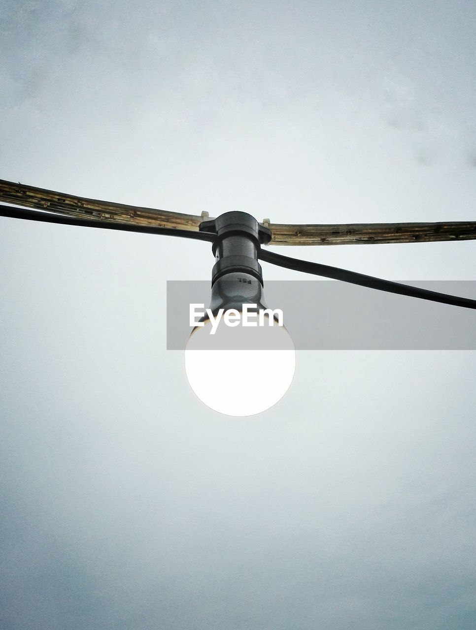 LOW ANGLE VIEW OF ILLUMINATED LIGHT BULBS HANGING FROM CEILING